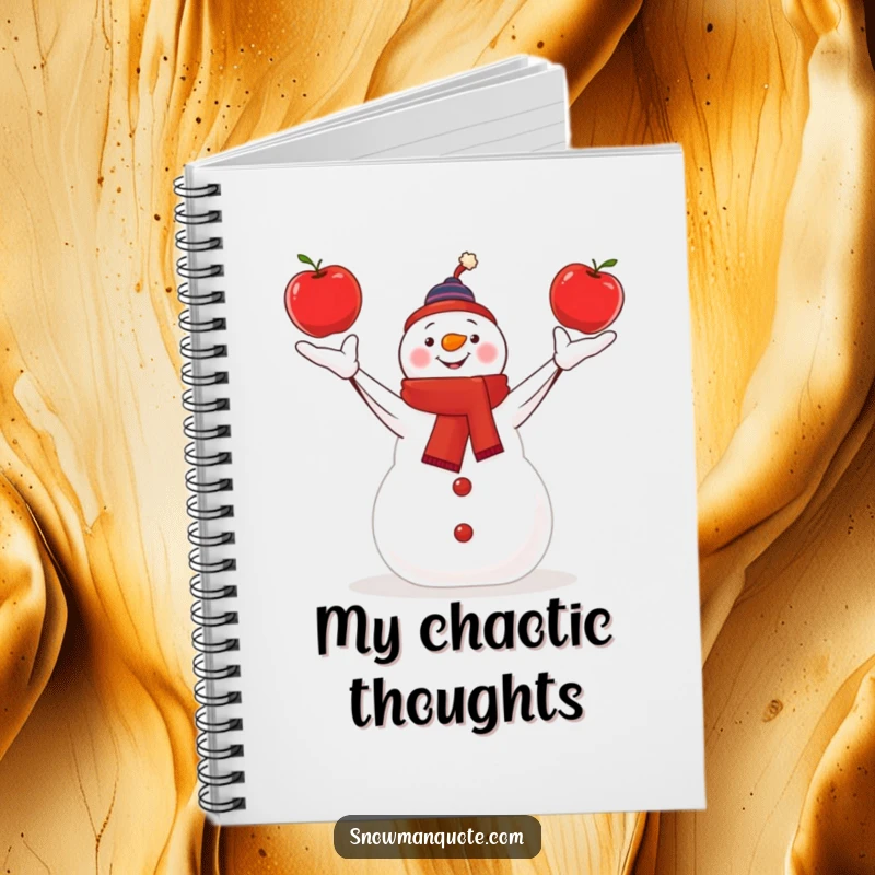 Funny snowman skillfully juggling three bright red apples, depicted on a notebook cover for creativity.